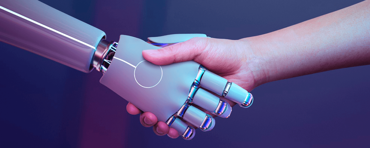 Uma mão de uma pessoa apertando a mão de um robô, para ilustrar a inteligência artificial.