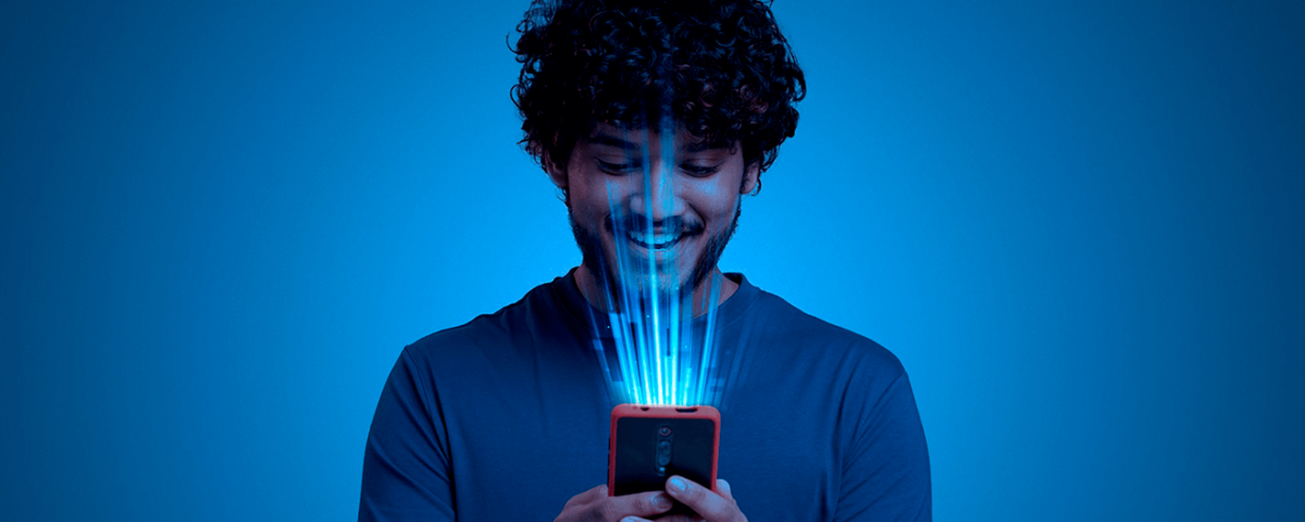 Homem sorrindo com celular na mão. Artigo Marketing Empresarial| Blog Agência Magna.